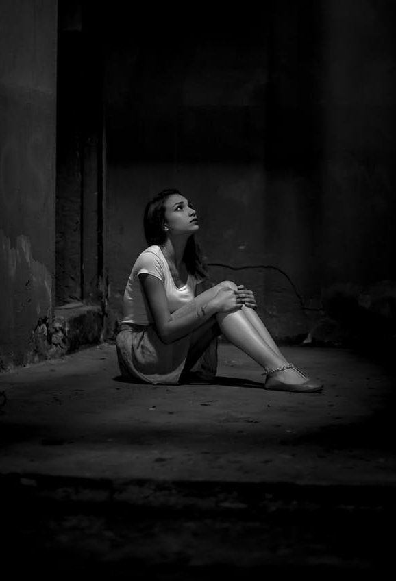 monochrome photo of woman sitting on floor